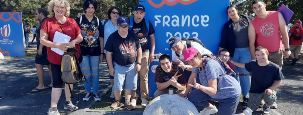 Photo de résidents du CDTPI devant un panneau "Coup du monde de Rugby 2023"